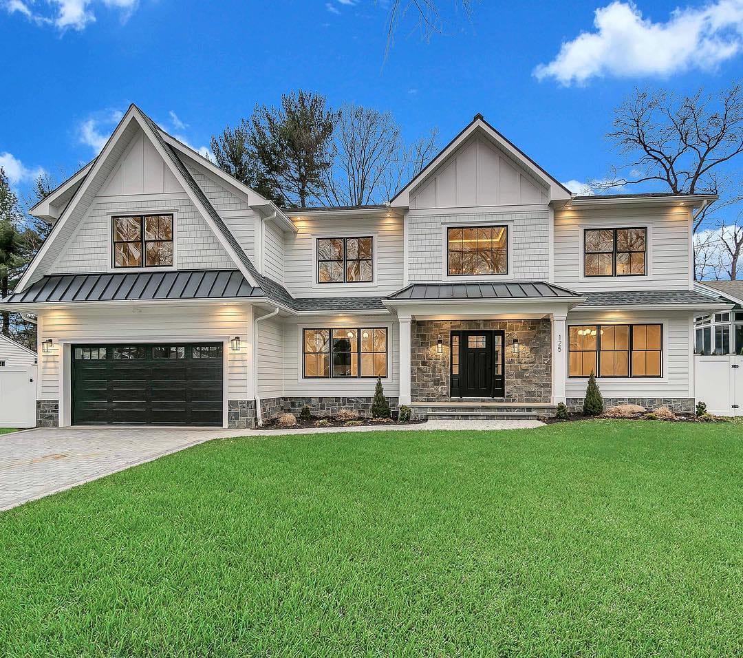Black Windows Add Modern Twist to Traditional Farmhouse tan modern farmhouse exterior with black windows and doors