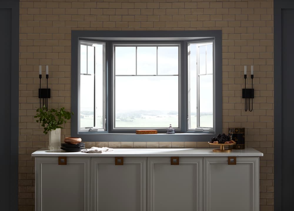 Bay Window Brings Classic Design To Home's Architecture Bay window with white frames and blue trim directly above kitchen counter