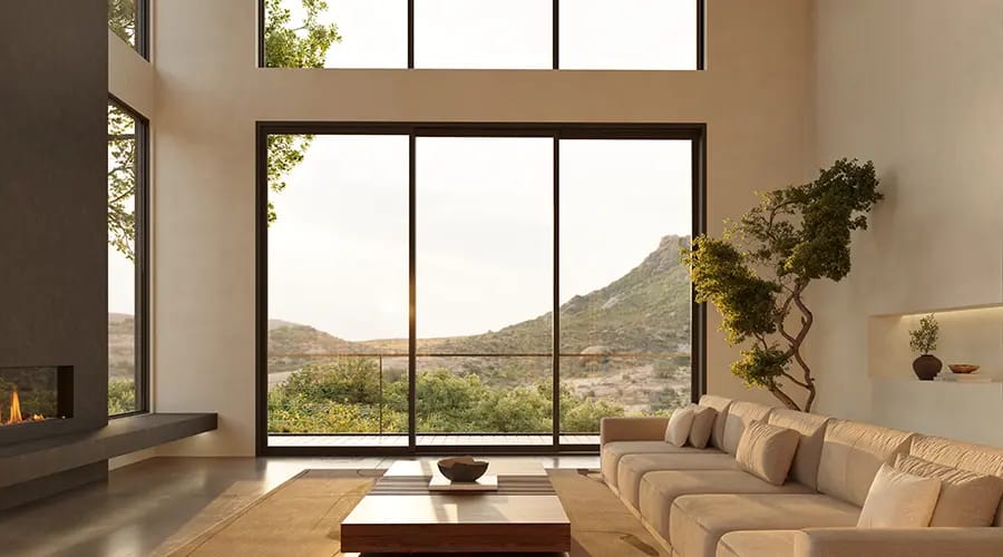 Three large picture windows sit above a three-panel sliding door, bringing desert views into the contemporary living room.