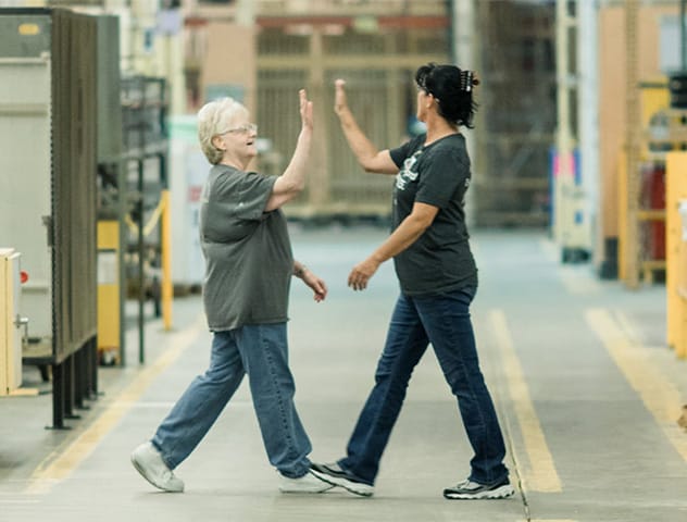 Pella Employees High-five in Factory