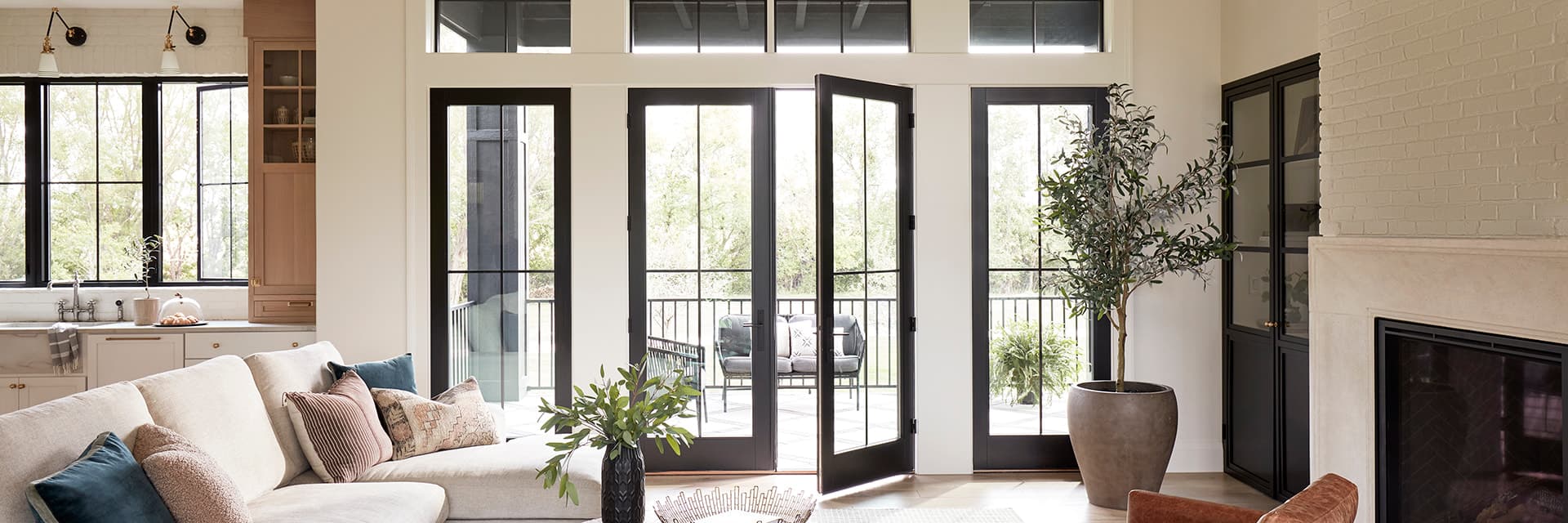 French doors behind a contemporary living room that open to a patio