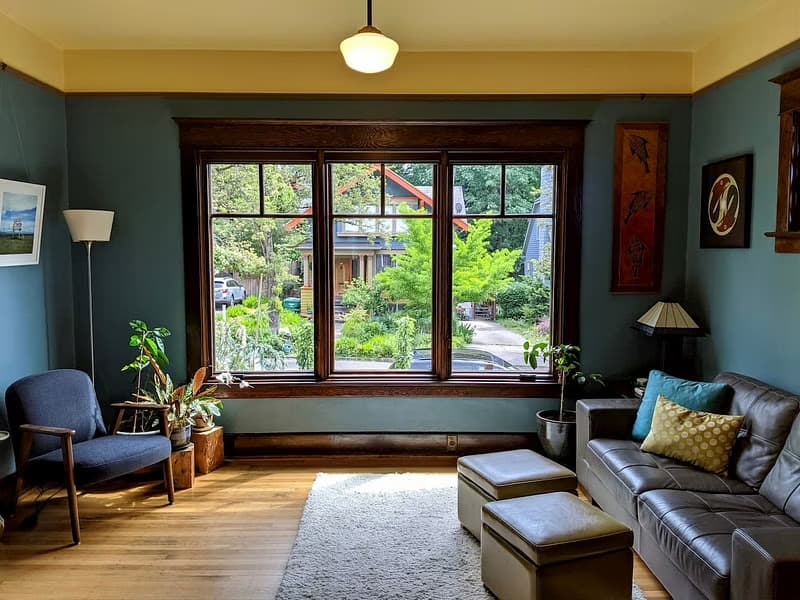A living room has three wood casement windows with traditional grilles.