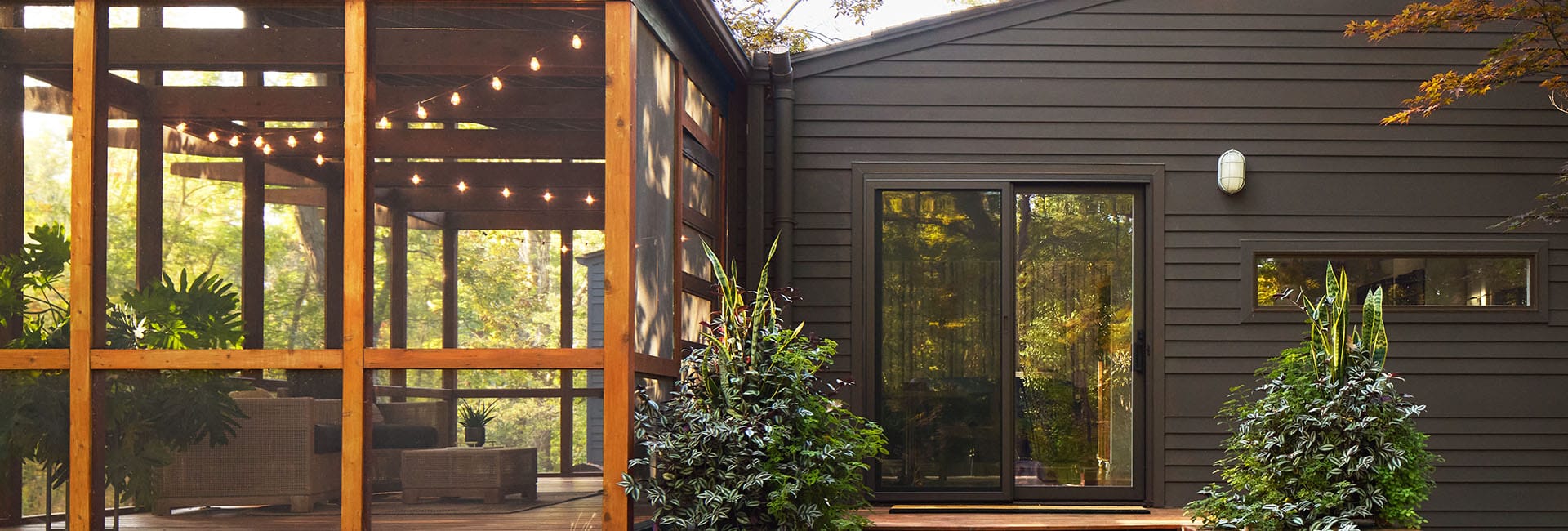 an expansive white sliding patio door with blinds-between-the-glass opens to a beautiful green backyard