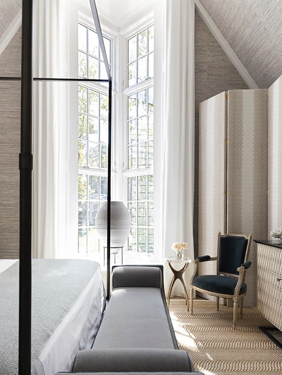 White bedroom windows with a traditional grille pattern and chic furniture.