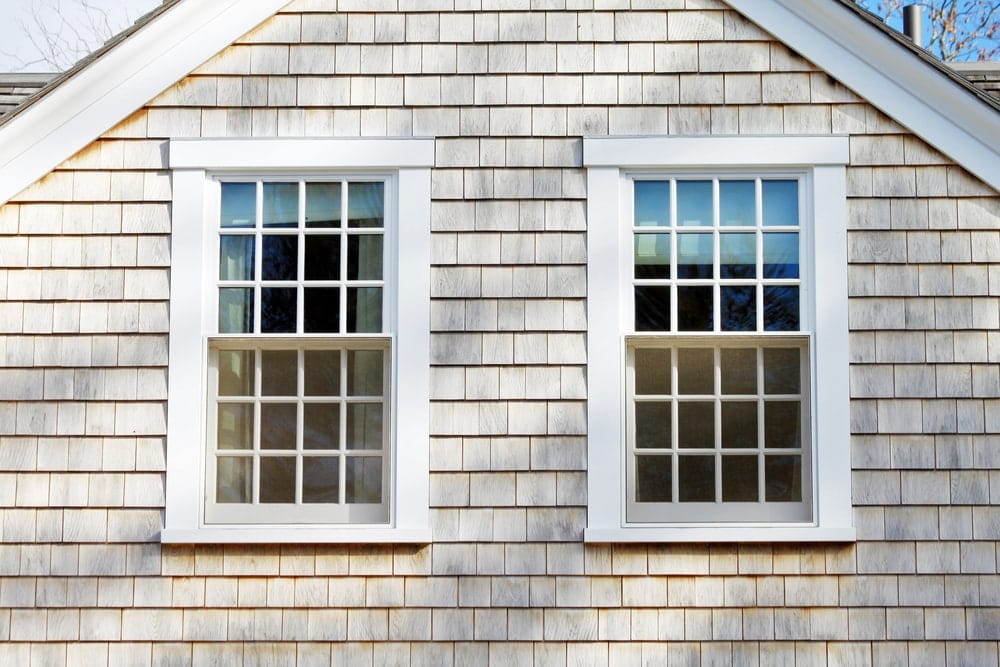Traditional Window Grilles For Authentic Farmhouse Style Two white double-hung windows with traditional grilles on shingle siding farmhouse