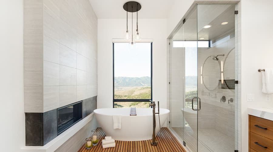 Tall Window Behind Tub Next to Fireplace and Shower