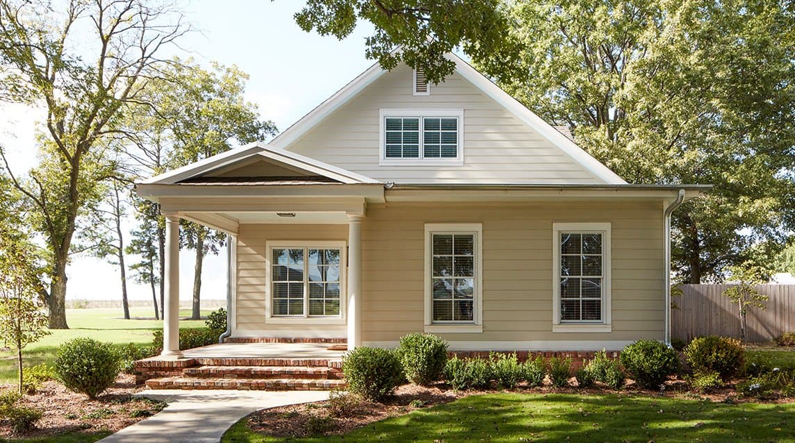 exterior shot of yellow home with cracked windows